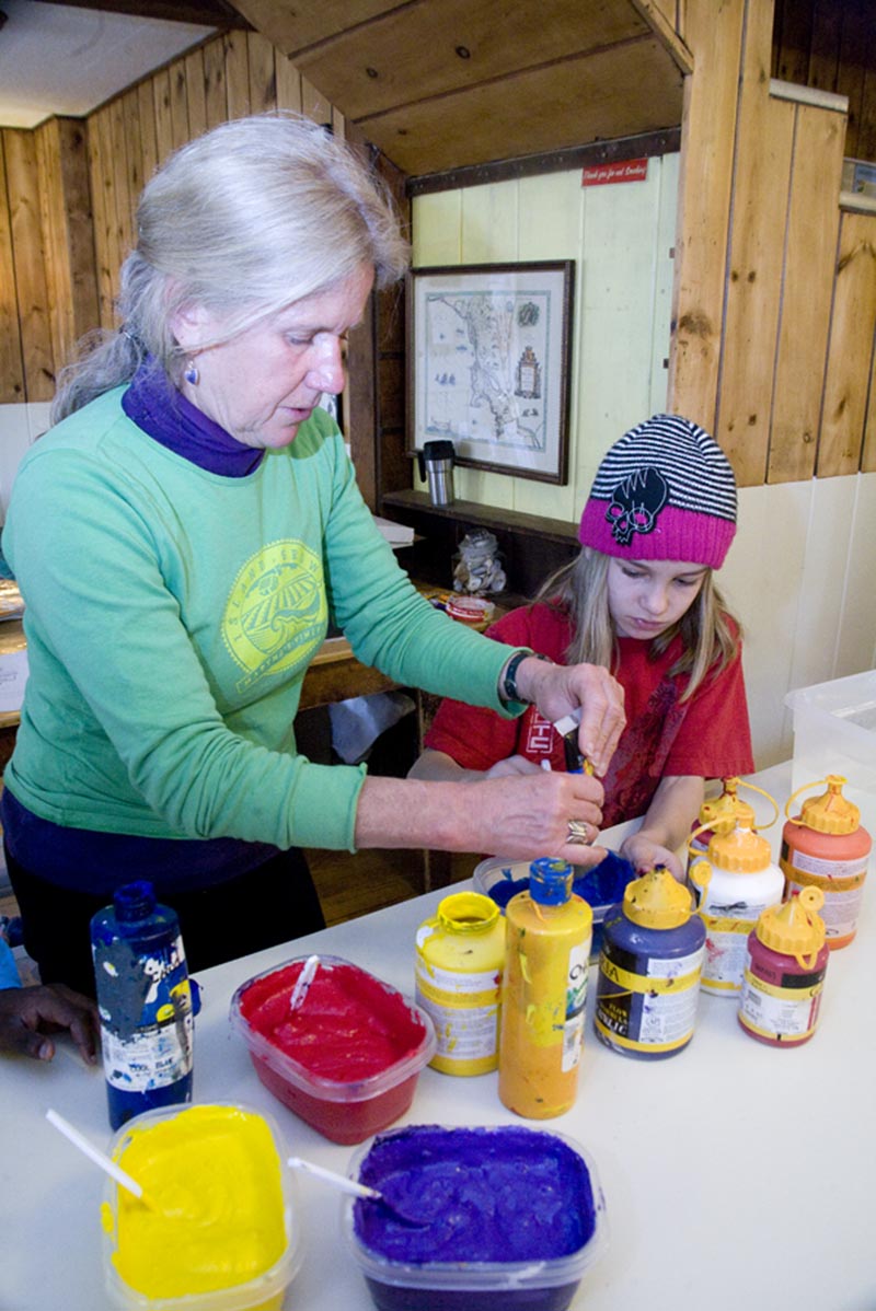 woman teaches young girl crafts