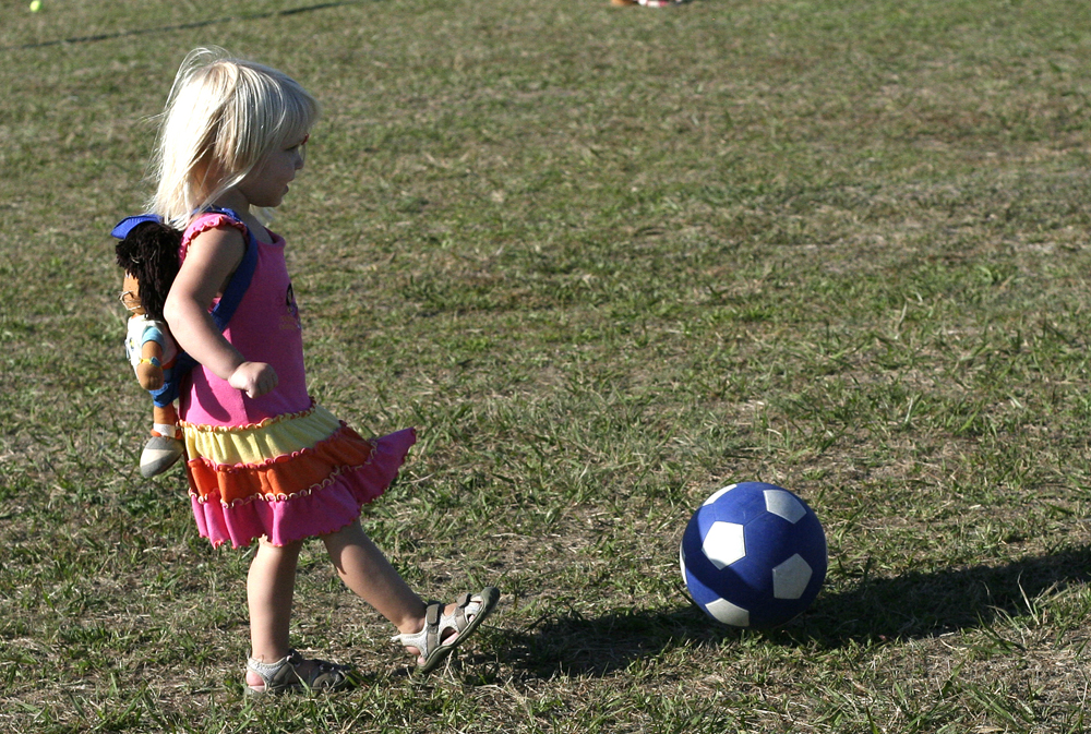 little girl kicks ball