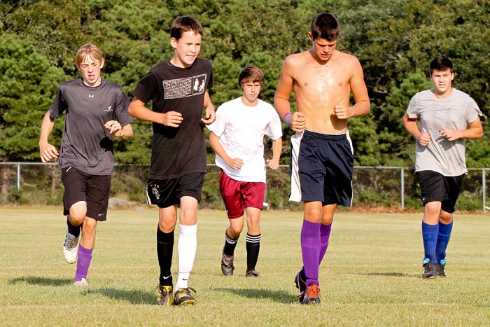 boys running soccer field