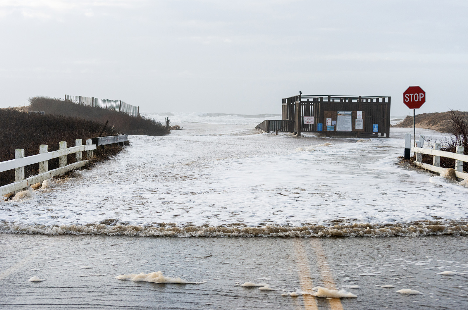 A wave rushes down Katama road from the left fork entrance to South Beach.