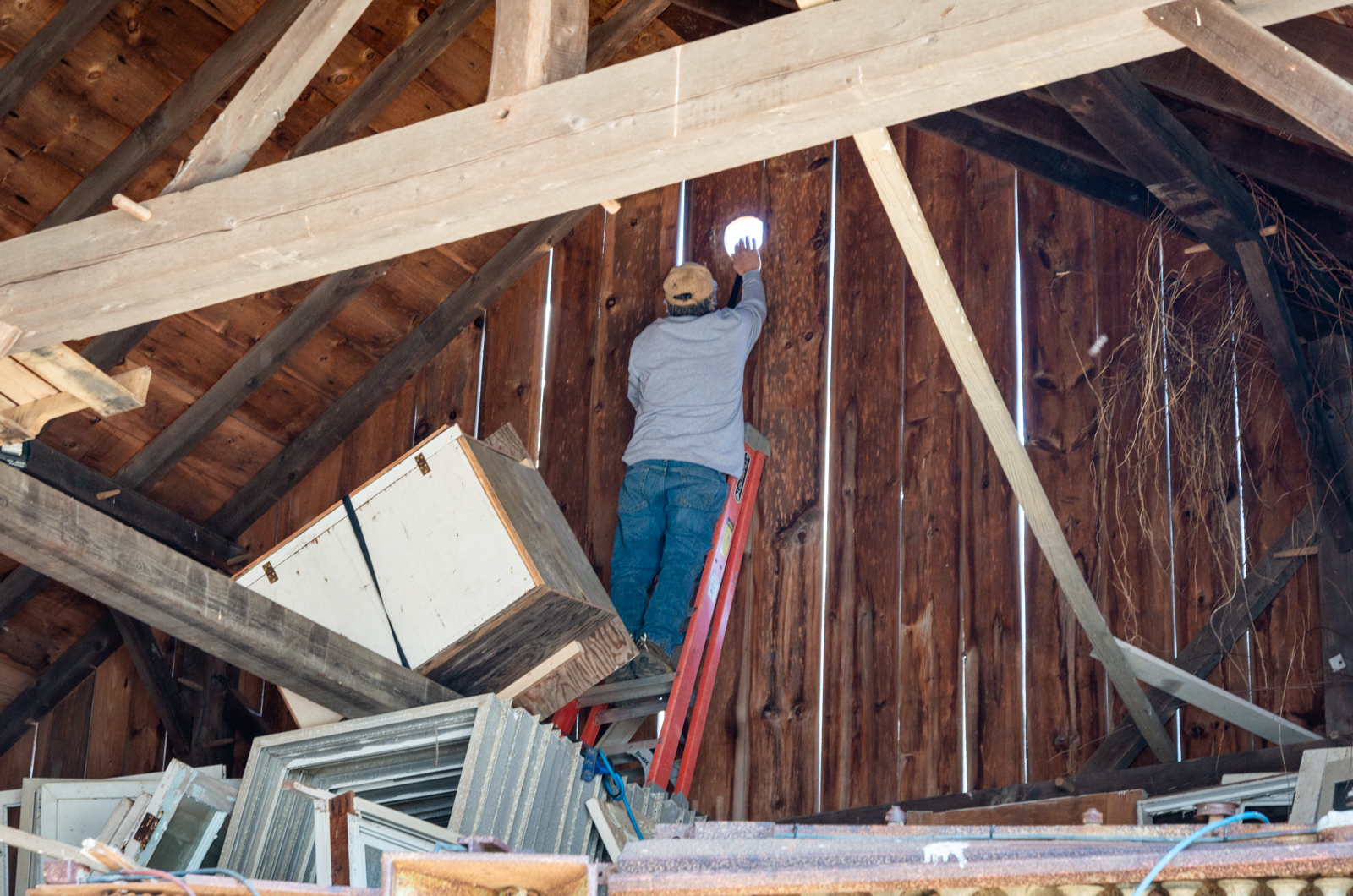 Andrew Woodruff prepares barn wall for owl box.