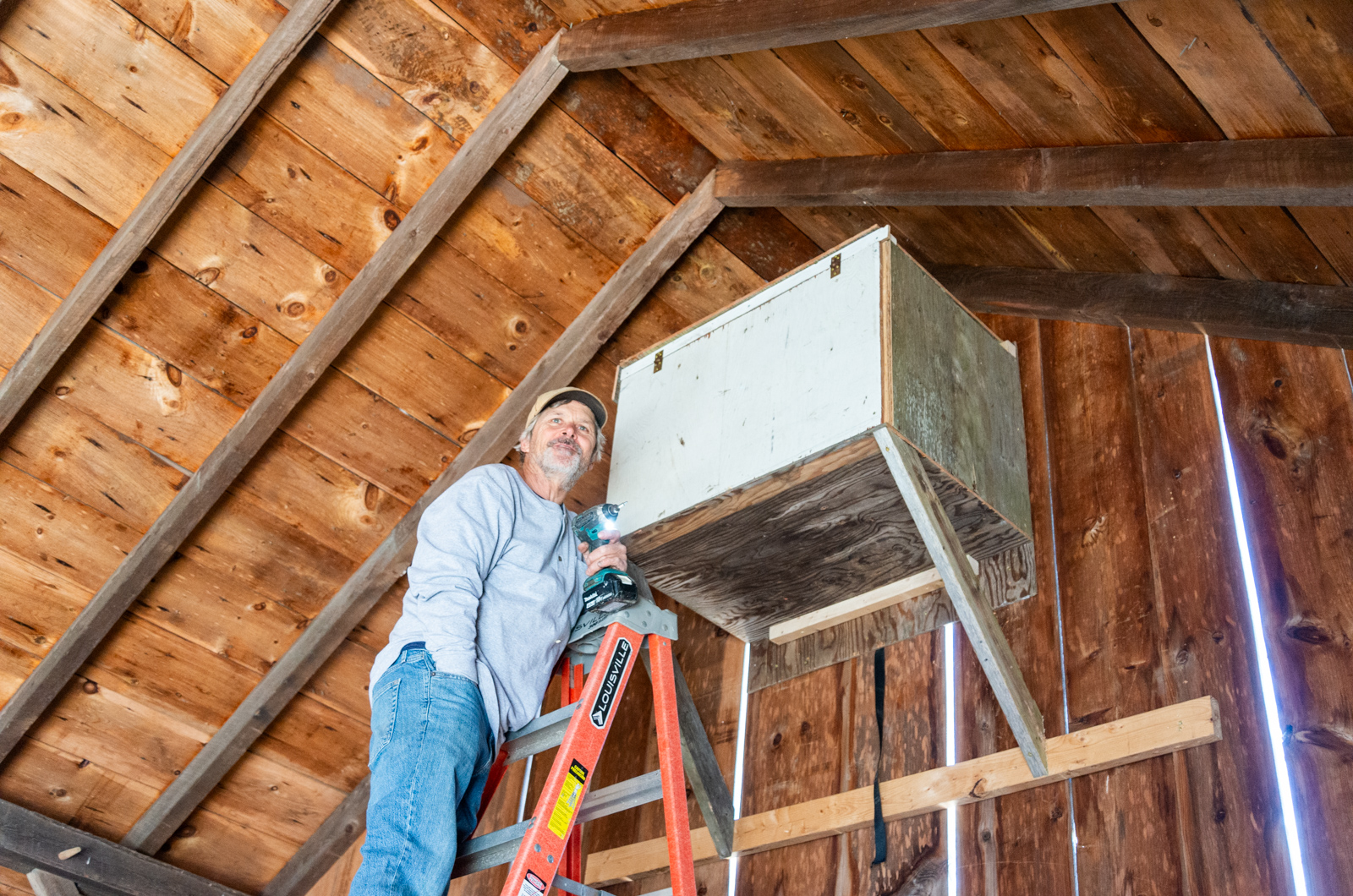 Andrew Woodruff next to the newly inhabited owl box in his barn.