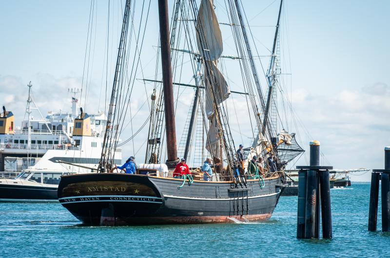 The crew readies to dock as a ferry passes by behind.