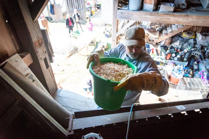 Andrew Woodruff carrying wood shavings into the loft.