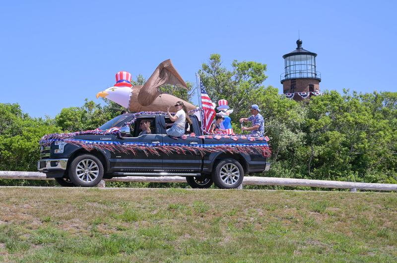 Inflatable patriotic characters pass the Gay Head light house.