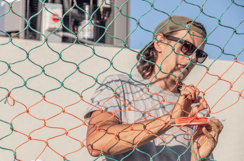 Ian Andres participates in the net mending competition.