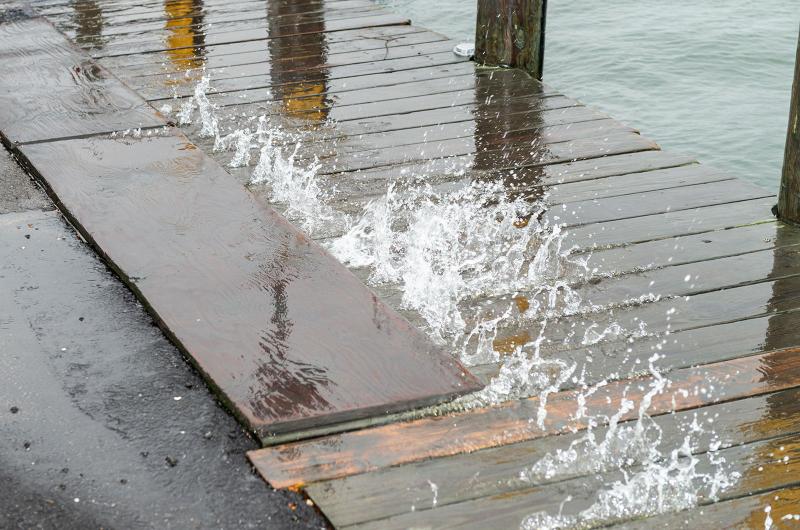 Waves splash through dock boards in Edgartown harbor.