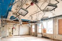 Recessed lighting fixtures remain after drop-ceiling is removed.