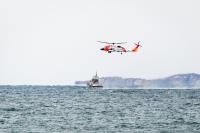 Helicopter makes multiple approaches toward Coast Guard cutter.