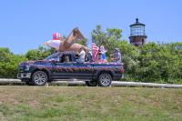 Inflatable patriotic characters pass the Gay Head light house.