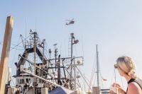 A Coast Guard flies over the harbor for a demonstration.