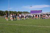Girls lacrosse team running laps.
