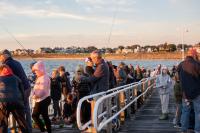 Families line the docks as the sun rises over Oak Bluffs.